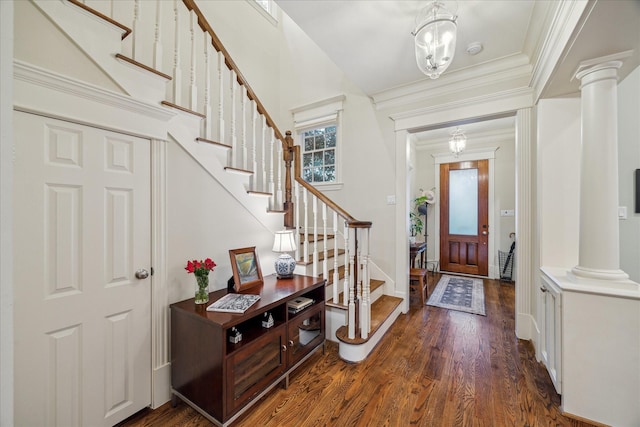 entrance foyer with stairs, ornamental molding, dark wood finished floors, and ornate columns