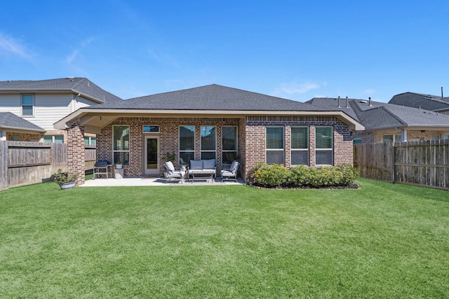 rear view of house with a patio, brick siding, a lawn, and a fenced backyard