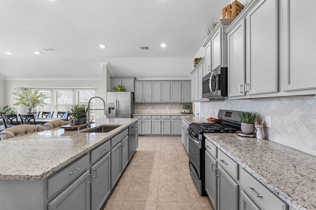 kitchen with visible vents, a sink, gray cabinets, stainless steel appliances, and backsplash