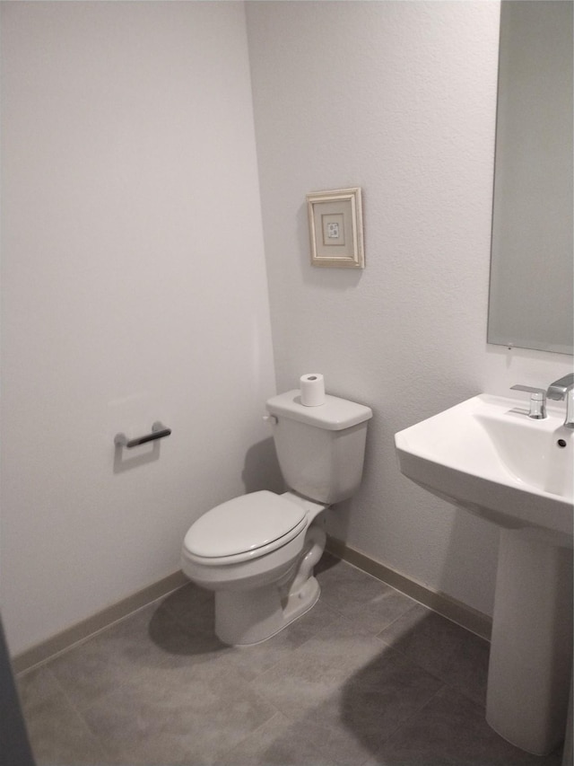 bathroom with toilet and baseboards