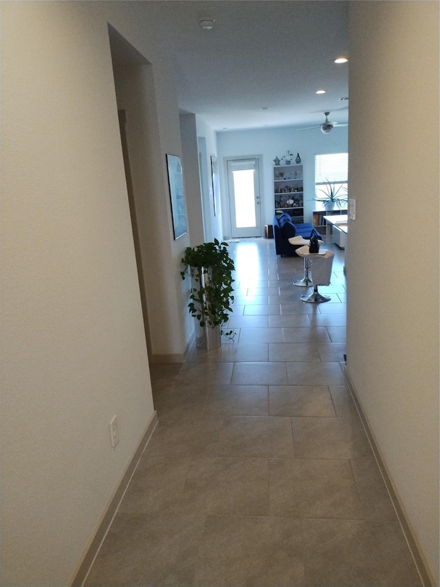 hall with tile patterned floors and baseboards