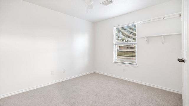 spare room with a ceiling fan, baseboards, visible vents, and carpet flooring