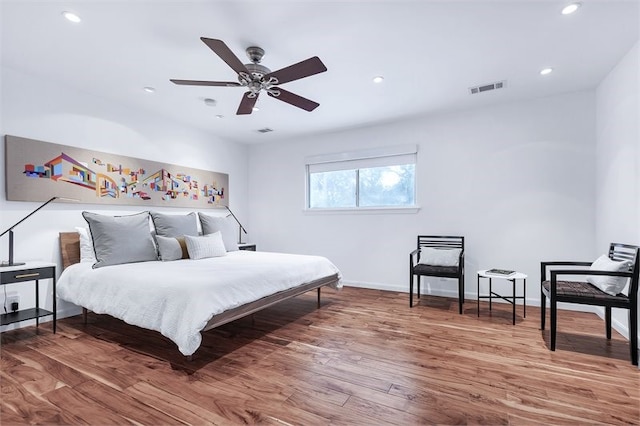 bedroom featuring baseboards, visible vents, wood finished floors, and recessed lighting