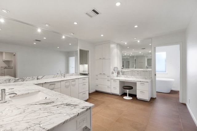 full bath with recessed lighting, a soaking tub, two vanities, visible vents, and a sink