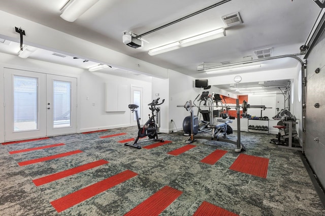 workout area featuring a garage, french doors, visible vents, and baseboards