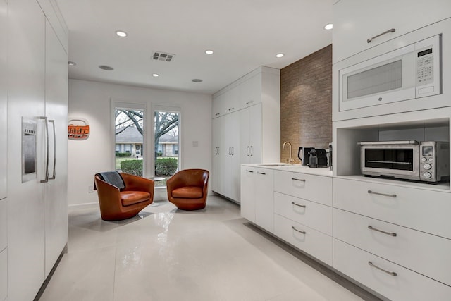 living area with a toaster, concrete floors, visible vents, and recessed lighting