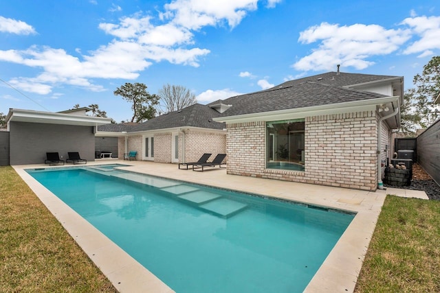 pool featuring a lawn, a patio area, and a fenced backyard