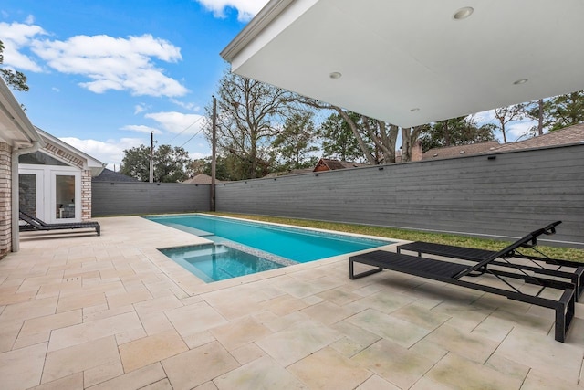 view of pool with a fenced backyard, a patio, and an in ground hot tub