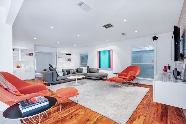 living room with wood finished floors, visible vents, and recessed lighting