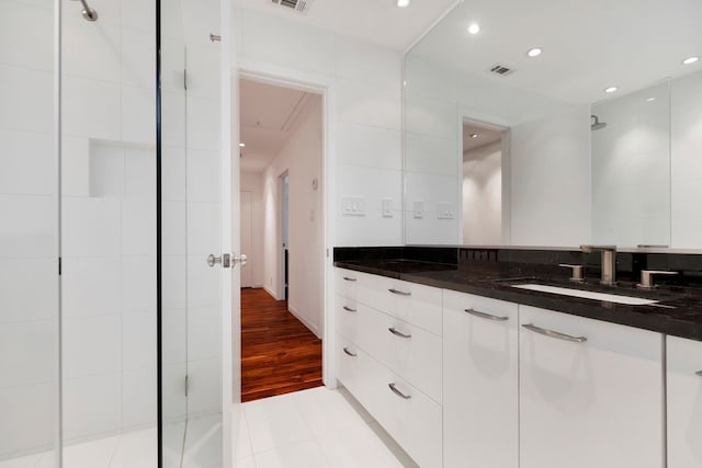 full bath featuring visible vents, tile walls, a shower stall, and vanity