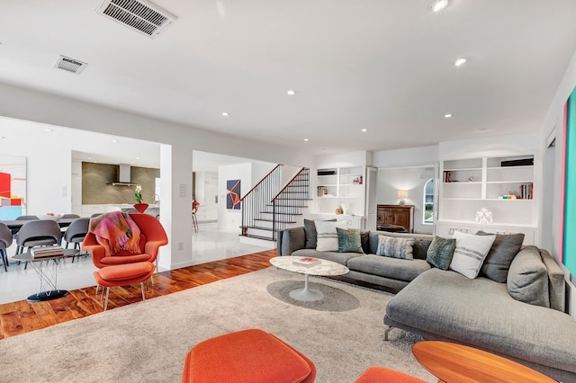 living area with stairway, visible vents, wood finished floors, and recessed lighting