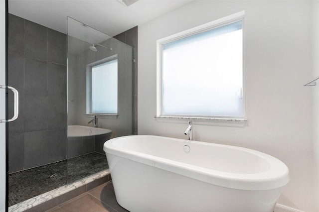 full bathroom with a freestanding tub, a shower stall, and tile patterned floors