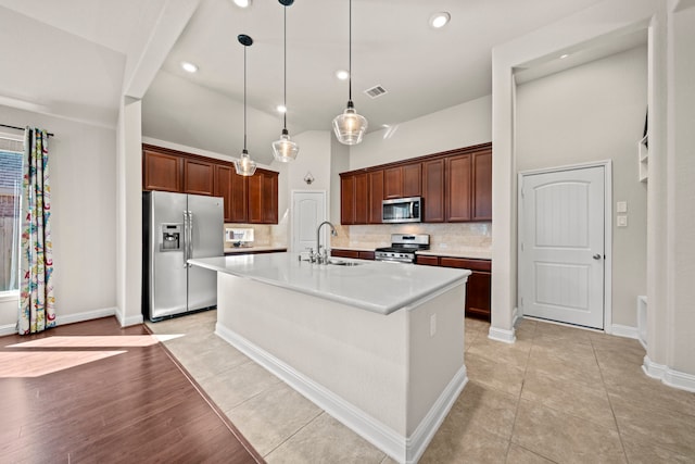 kitchen featuring stainless steel appliances, a sink, visible vents, light countertops, and tasteful backsplash