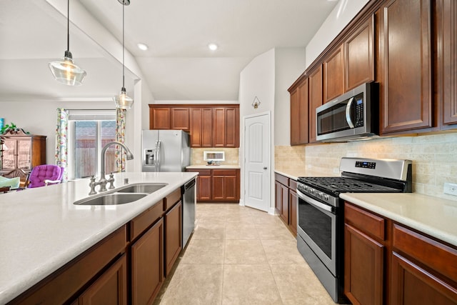 kitchen featuring hanging light fixtures, appliances with stainless steel finishes, light countertops, and a sink