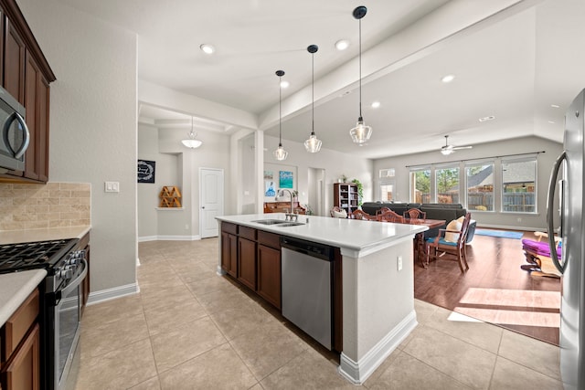 kitchen featuring light tile patterned flooring, stainless steel appliances, a sink, light countertops, and tasteful backsplash