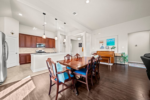 dining area featuring vaulted ceiling, wood finished floors, visible vents, and recessed lighting