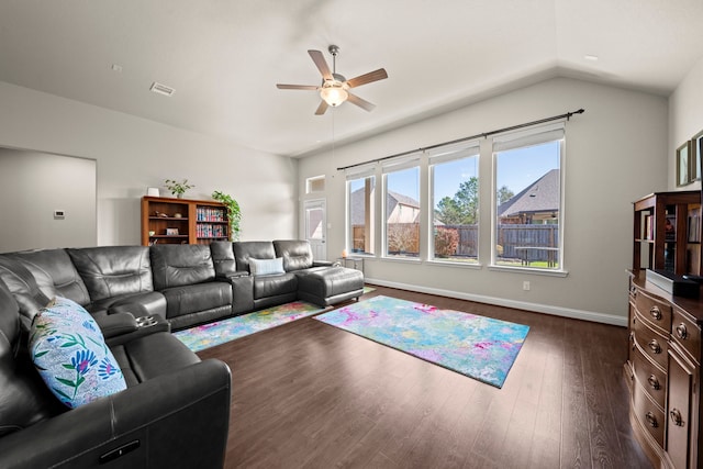 living room featuring lofted ceiling, visible vents, baseboards, a ceiling fan, and dark wood-style floors