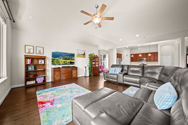 living area with dark wood-style flooring, visible vents, vaulted ceiling, and baseboards