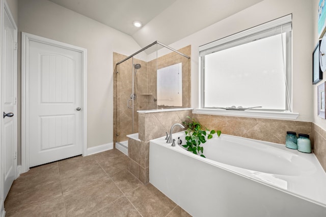 bathroom with a garden tub, a shower stall, a wealth of natural light, and tile patterned floors