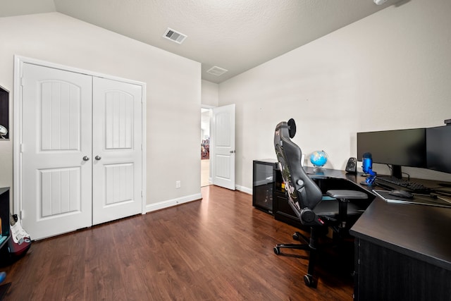 office space featuring lofted ceiling, visible vents, baseboards, and wood finished floors