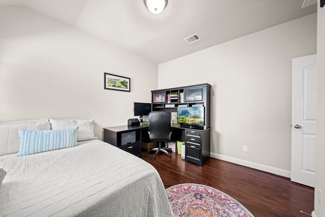 bedroom with vaulted ceiling, dark wood-type flooring, visible vents, and baseboards