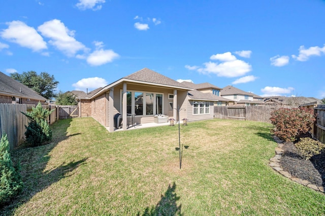 back of house with a fenced backyard and a yard