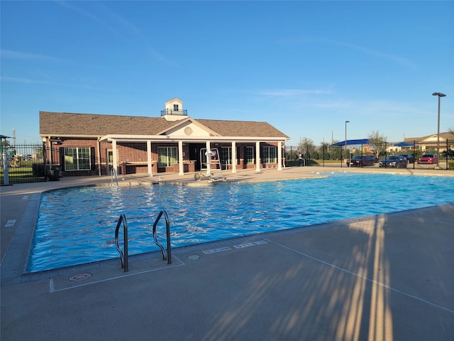 pool featuring fence and a patio