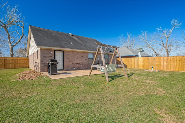 306 Marion St, Brazoria, TX 77422 - rear view of house featuring brick siding, a patio, and a shingled roof