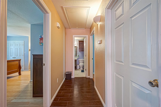 306 Marion St, Brazoria, TX 77422 - hall with attic access, wood finished floors, baseboards, and a textured wall