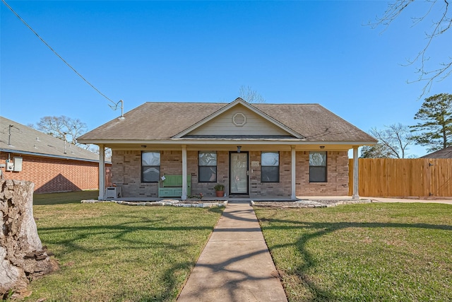 306 Marion St, Brazoria, TX 77422 - view of front of house featuring covered porch, roof with shingles, and brick siding