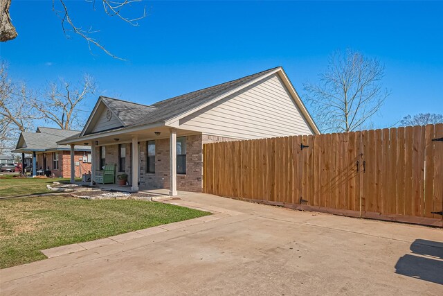 306 Marion St, Brazoria, TX 77422 - view of property exterior featuring covered porch, roof with shingles, and brick siding