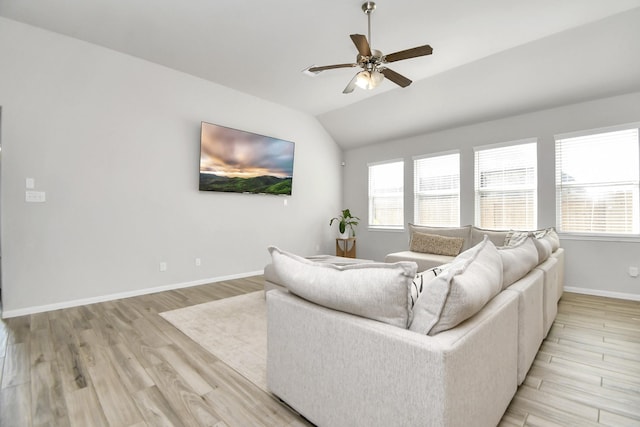 living area with light wood-type flooring, vaulted ceiling, baseboards, and ceiling fan