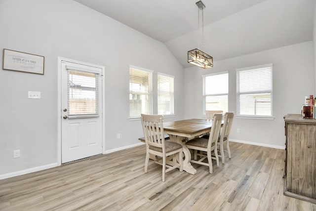 dining space featuring lofted ceiling, plenty of natural light, light wood-style flooring, and baseboards