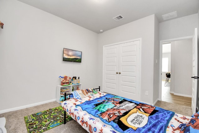 bedroom featuring carpet, baseboards, visible vents, and a closet