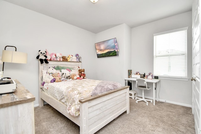 bedroom featuring light colored carpet and baseboards