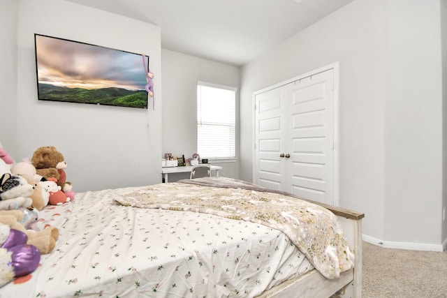 bedroom with a closet, carpet flooring, and baseboards