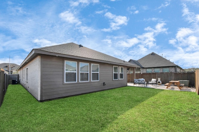 rear view of property featuring a patio area, a lawn, a fenced backyard, and brick siding