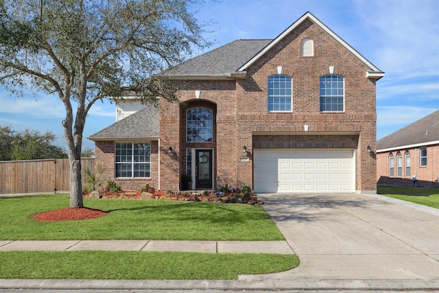 traditional-style home featuring brick siding, a shingled roof, concrete driveway, fence, and a front yard