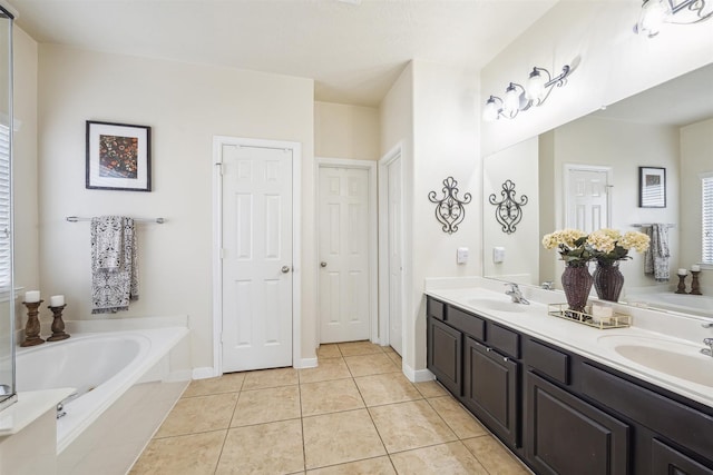 full bathroom featuring double vanity, tile patterned flooring, a sink, and a bath