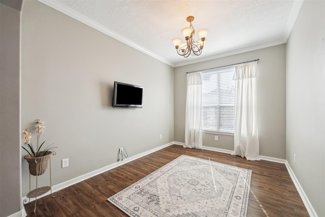 interior space with baseboards, crown molding, a chandelier, and wood finished floors