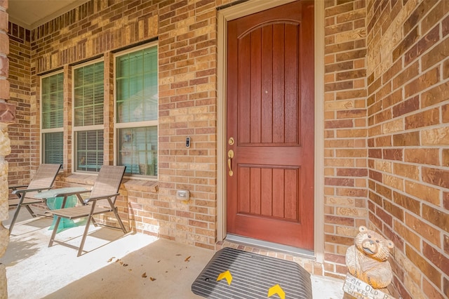 property entrance featuring brick siding