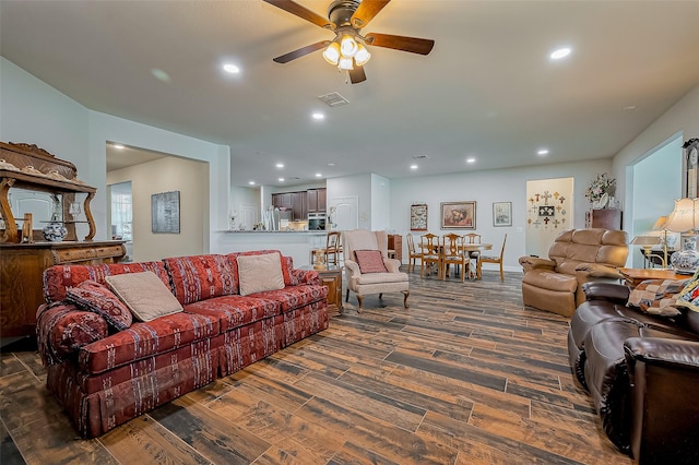 living room featuring dark wood-style floors, ceiling fan, visible vents, and recessed lighting