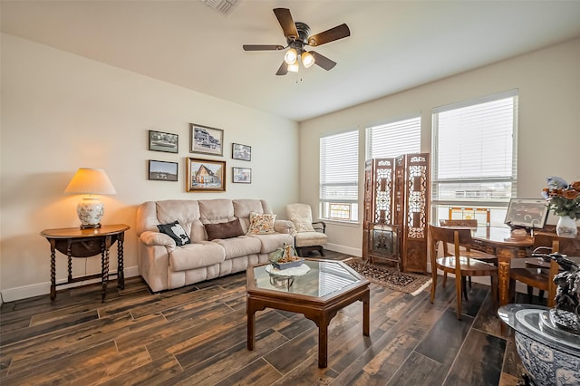 living room featuring dark wood-style floors, ceiling fan, visible vents, and baseboards