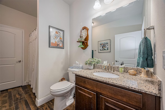 full bath featuring vanity, wood finished floors, and toilet