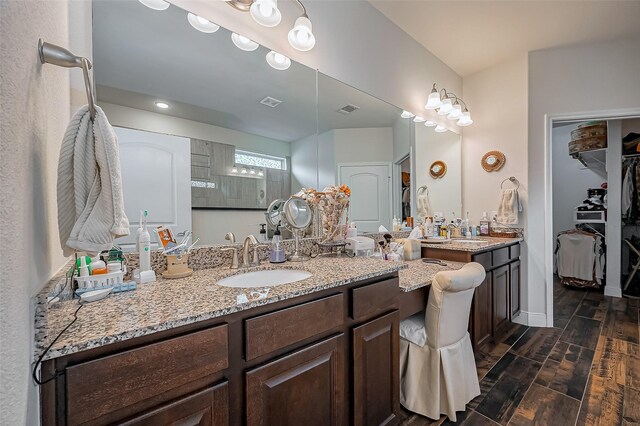 full bathroom featuring visible vents, a spacious closet, wood tiled floor, vanity, and baseboards