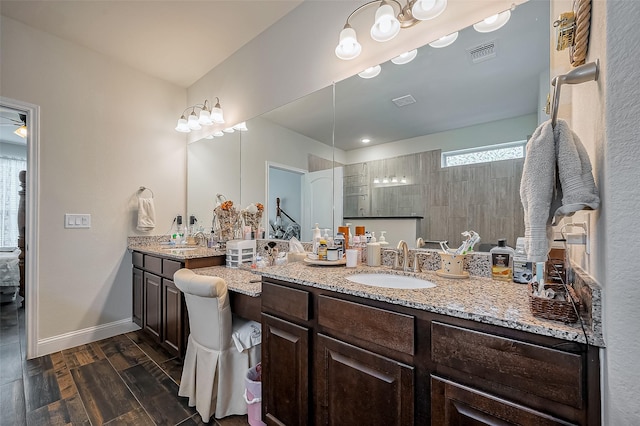 bathroom featuring baseboards, visible vents, ceiling fan, wood finished floors, and vanity