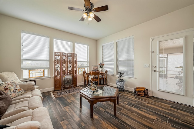 living area with ceiling fan, baseboards, and dark wood-style flooring