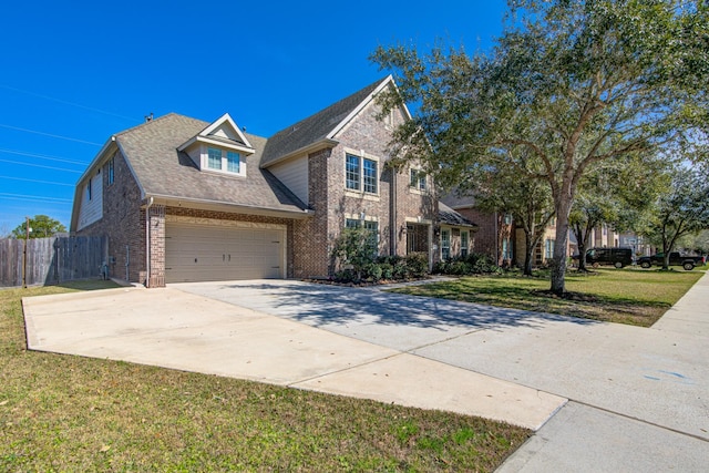 traditional home featuring brick siding, concrete driveway, an attached garage, a front yard, and fence