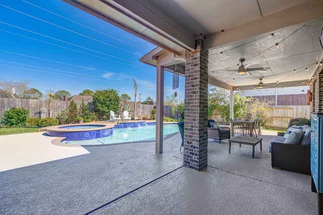 view of pool featuring a pool with connected hot tub, an outdoor hangout area, a ceiling fan, a patio area, and a fenced backyard