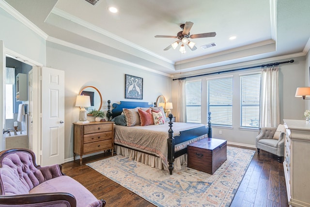 bedroom featuring a tray ceiling, dark wood-type flooring, visible vents, and baseboards